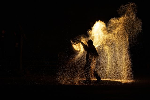 A performer walks carrying fire during a fire spectacle to celebrate Mid Autumn Festival in Beijing, China, 15 September 2024. The Mid-Autumn Festival, also known as the Mooncake Festival, is celebrated on the 15th of the eighth lunar month. (Photo by Andres Martinez Casares/EPA/EFE)