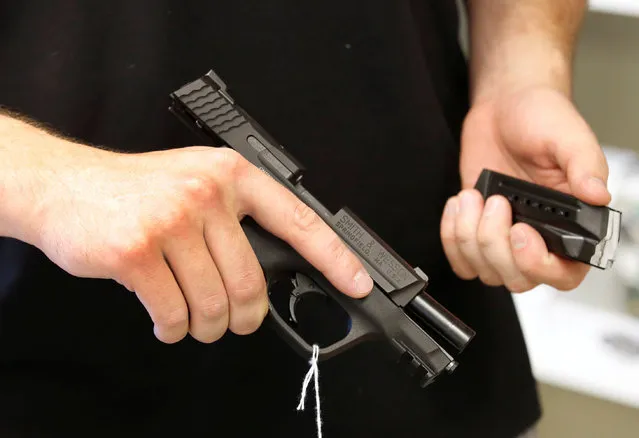 Salesman Ryan Martinez hold an Smith & Wesson handgun and magazine at the “Ready Gunner” gun store in Provo, Utah, U.S., June 21, 2016. (Photo by George Frey/Reuters)