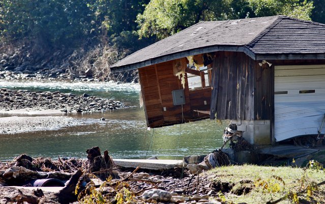 The Pigeon River flows partly under a destroyed building in the aftermath of Hurricane Helene, in Cruso, North Carolina on October 3, 2024. (Photo by Jonathan Drake/Reuters)