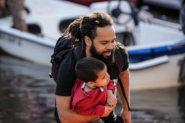 A man and child leave a rescue boat after high floodwaters entered their apartment in the aftermath of Hurricane Milton, Thursday, October 10, 2024, in Clearwater, Fla. (Photo by Mike Stewart/AP Photo)