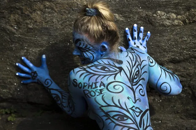 Debbie McCabe, of New Jersey, poses after being painted at Columbus Circle as body-painting artists gathered to decorate nude models as part of an event featuring artist Andy Golub, Saturday, July 26, 2014, in New York. Golub says New York was the only city in the country that would allow his inaugural Bodypainting Day. (Photo by John Minchillo/AP Photo)