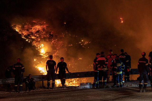 Firefighters look at a wildfire burning on Mount Parnitha, in Athens, Greece on August 24, 2023. (Photo by Nicolas Economou/Reuters)