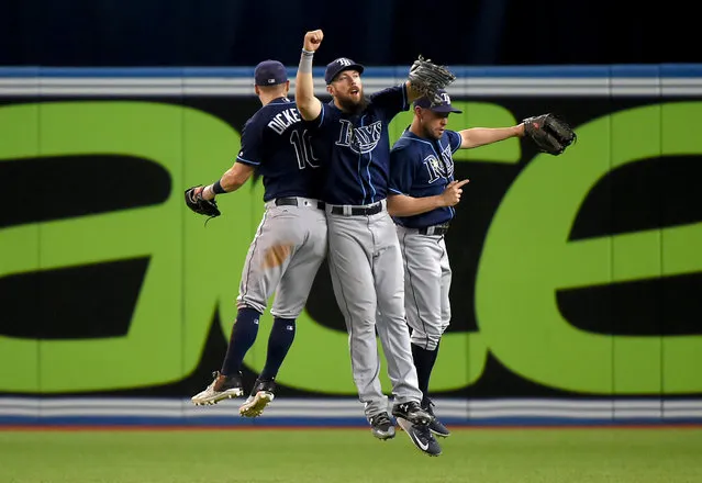 Tampa Bay Rays right fielder Steven Souza Jr. (20, center) jumps in celebration with left fielder Corey Dickerson (10) and center fielder Peter Bourjos (18) after defeating the Toronto Blue Jays at Rogers Centre in Toronto, Ontario, Canada on August 15, 2017. (Photo by Dan Hamilton/USA TODAY Sports)
