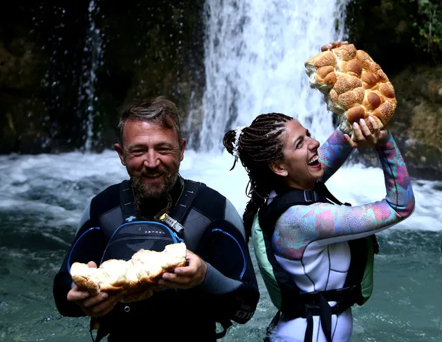 Bulgarian couple Veselin and Spasiyana Paunovski react after a traditional bread breaking, during their wedding ceremony, in front of a waterfall in the river Tara, before a rafting tour in Scepan Polje, Bosnia and Herzegovina August 18, 2017. (Photo by Dado Ruvic/Reuters)
