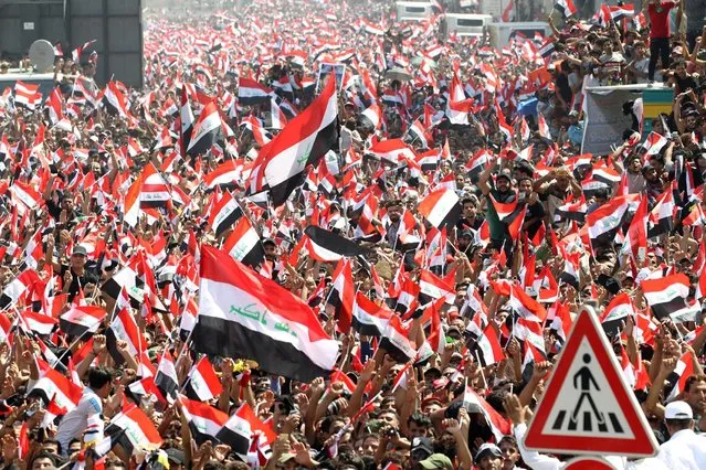 Supporters of Iraqi Shi'ite cleric Moqtada al-Sadr shout slogans during a protest against corruption at Tahrir Square in Baghdad, July 15, 2016. Protesters packed in to Baghdad’s Tahrir Square and cheered as a spokesman for the Shia cleric issued a list of demands that included the sacking of the country’s top three leaders – the prime minister, president and the parliament speaker. Haider al-Abadi, prime minister, faces intense pressure to follow through on promised reforms and pledges to crack down on state corruption. A string of bomb attacks in Baghdad and other cities in recent weeks, which have killed more than 300 people, have exacerbated the grim mood. (Photo by Alaa Al-Marjani/Reuters)