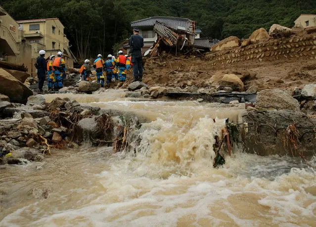 Members of police continue the search for missing people among the debris of houses destroyed by a landslide caused by torrential rain at the site of a landslide in a residential area on August 20, 2014 in Hiroshima, Japan. (Photo by Buddhika Weerasinghe/Getty Images)