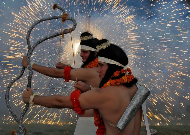 Artists dressed as Hindu gods Rama and Laxman act as fireworks explode during Vijaya Dashmi, or Dussehra festival celebrations in Chandigarh, September 30, 2017. (Photo by Ajay Verma/Reuters)