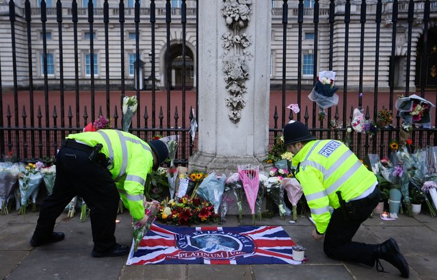 Police officers place flowers at Buckingham Palace, following the passing of Britain's Queen Elizabeth, in London, Britain on September 9, 2022. (Photo by Toby Melville/Reuters)