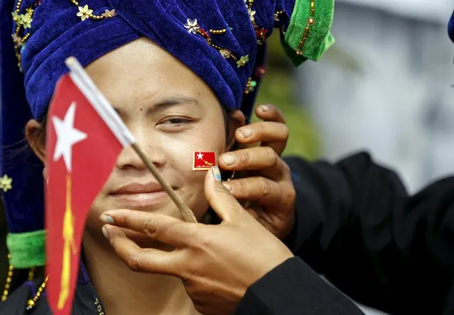 An ethnic Pa'O woman has a National League for Democracy party flag put on her cheek as she waits for Myanmar pro-democracy leader Aung San Suu Kyi to arrive to give a speech on voter education at the Hsiseng township in Shan state, Myanmar September 5, 2015. (Photo by Soe Zeya Tun/Reuters)