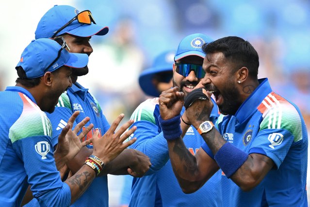 India's Hardik Pandya (R) celebrates with teammates after taking the wicket of Pakistan's Saud Shakeel during the ICC Champions Trophy one-day international (ODI) cricket match between Pakistan and India at the Dubai International Stadium in Dubai on February 23, 2025. (Photo by Jewel Samad/AFP Photo)