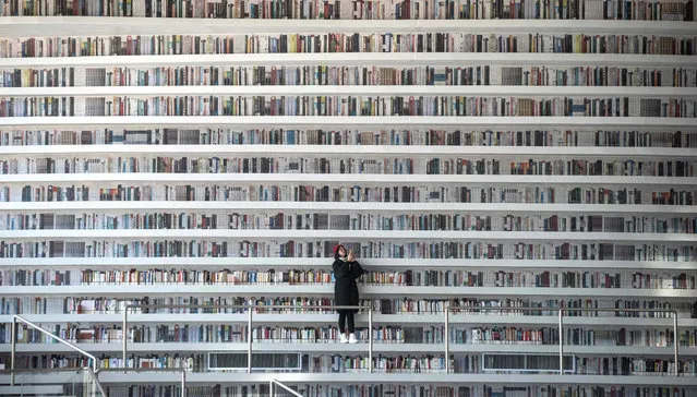 This picture taken on November 14, 2017 shows a woman taking pictures at the Tianjin Binhai Library. (Photo by Fred Dufour/AFP Photo)