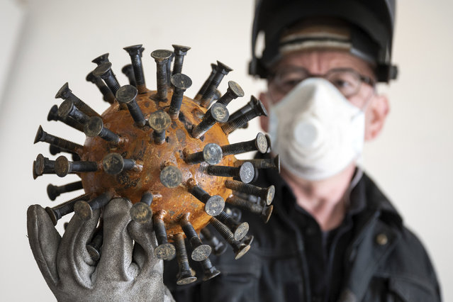 The artist Sebastian Wien shows a coronavirus sculpture “Here and Now” at his studio in Dortmund, Germany on April 15, 2020. (Photo by Bernd Thissen/dpa via AP Photo)