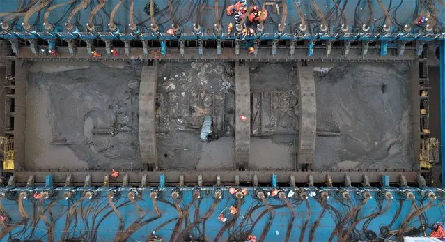This aerial photo taken on November 21, 2022 shows a view of the salvage operation of the Yangtze No. 2 Ancient Shipwreck in Shanghai, east China. An ancient shipwreck, one of the largest and best-preserved wooden shipwrecks discovered underwater in China to date, was lifted out of waters in Shanghai early Monday. The Yangtze No. 2 Ancient Shipwreck dates back to the reign of Emperor Tongzhi (1862-1875) of the Qing Dynasty. This salvage could offer a useful glimpse of shipbuilding technology during the Qing Dynasty. A milestone in China's underwater archaeology efforts, the sunken ship was detected in 2015 during a key underwater survey. (Photo by Xinhua News Agency/Rex Features/Shutterstock)