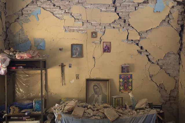 An altar to the Virgin of Guadalupe is covered with fallen debris inside the earth-damaged home where Larissa Garcia, 24, lived with her family in Juchitan, Oaxaca state, Mexico, on September 9, 2017. The family was caught under rubble when the house partially collapsed, leaving Garcia with a broken arm and her father with a head injury. Her mother, who had to be pulled out from underneath a foot-thick section of wall which collapsed on her back, remains in a wheelchair and unable to walk. (Photo by Rebecca Blackwell/AP Photo)