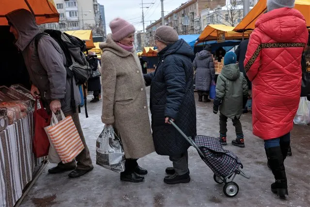 People shop for food at an outdoor market in central Kyiv on November 30, 2022 in Kyiv, Ukraine. Ukrainian officials expect a new wave of Russian bombing this week, with previous rounds targeting critical infrastructure and causing massive water and power cuts, including in the capital Kyiv. (Photo by Jeff J. Mitchell/Getty Images)