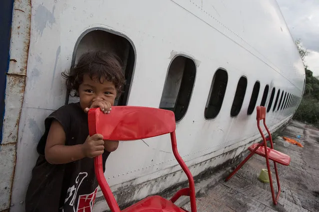 A young Thai boy plays outside his home in a disused airplane on September 12, 2015 in Bangkok, Thailand. (Photo by Taylor Weidman/Getty Images)