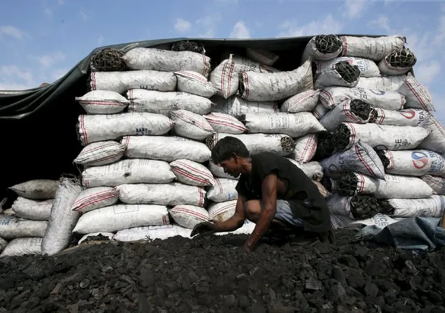 A worker sorts charcoal for cooking at a retailers repacking shop in Las Pinas, Metro Manila October 6, 2015. (Photo by Erik De Castro/Reuters)