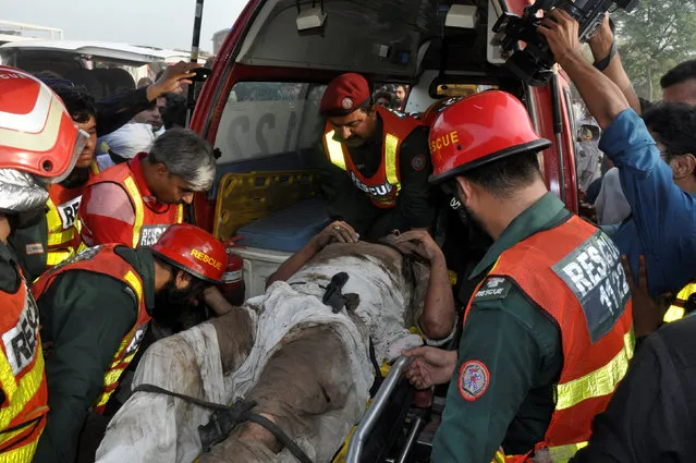 Rescue workers place a man in an ambulance after two trains collided near Multan, Pakistan September 15, 2016. (Photo by Khalid Chaudry/Reuters)