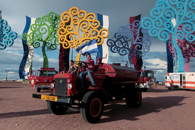 A man poses for pictures on a fire truck during an exhibition of old fire trucks in Managua, Nicaragua September 18, 2016. (Photo by Oswaldo Rivas/Reuters)