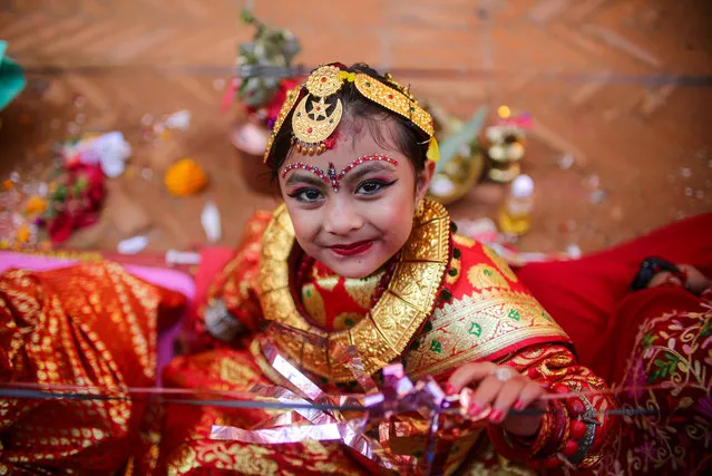 A girl from the Newa community looks at camera while participating in “ihi” ceremony in Bhaktapur on December 13, 2022. Before they reach their puberty girls from Newa community are ceremonially married to a bael fruit (wood apple), which is considered to be a symbol of Lord Vishnu. (Photo by Amit Machamasi/ZUMA Press Wire/Rex Features/Shutterstock)