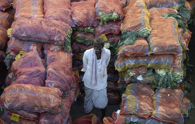 An Indian farmer with his produce waits to negotiate with traders at a wholesale vegetable market in Hyderabad on February 1, 2018. The Indian government is focusing on the agricultural sector in its annual budget, released on February 1. (Photo by Noah Seelam/AFP Photo)