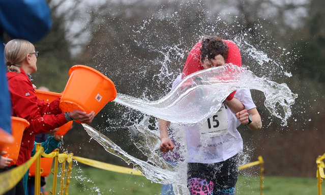 Stuart Jenkins and Hattie Crow get a soaking as they win the 16th UK wife-carrying race in Dorking, Surrey, United Kingdom on March 16, 2024. (Photo by Peter Tarry/The Times)