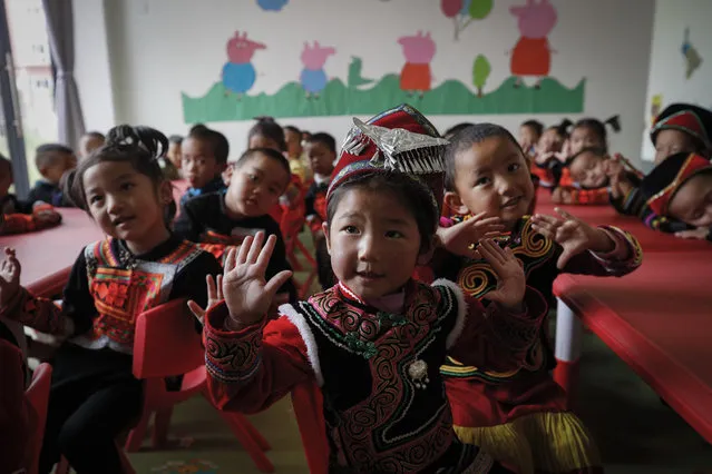 Ethnic minority children wearing their costumes learn to sing at a kindergarten class at the apartment houses compound built by the Chinese government in Yuexi county, southwest China's Sichuan province on September 11, 2020. China's ruling Communist Party says its initiatives have helped to lift millions of people out of poverty. But they can require drastic changes, sometimes uprooting whole communities. They fuel complaints the party is trying to erase cultures as it prods minorities to embrace the language and lifestyle of the Han who make up more than 90% of China’s population. (Photo by Andy Wong/AP Photo)