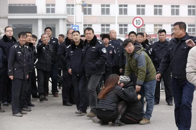 A woman cries in front of policemen after a coal mine fire accident at a hospital of Fu Mining Group Company in Fuxin, Liaoning province, November 26, 2014. Picture taken November 26, 2014. According to local media, at least 26 people were killed, 52 injured in the accident. (Photo by Reuters/Stringer)