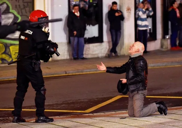 A man faces a police officer during riots prior to the UEFA Europa League round of 32, second leg soccer match between Athletic Bilbao and Spartak Moscow at San Mames stadium in Bilbao, Spain, 22 February 2018. (Photo by Miguel Tona/EPA/EFE)