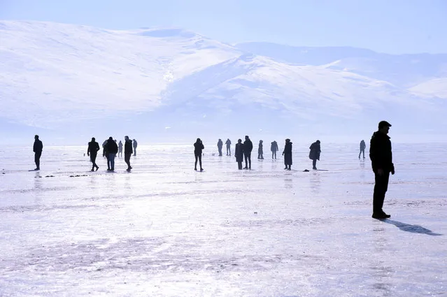 People walk on the frozen surface of Lake Cildir in Kars, Turkiye on January 22, 2023. (Photo by Gunay Nuh/Anadolu Agency via Getty Images)