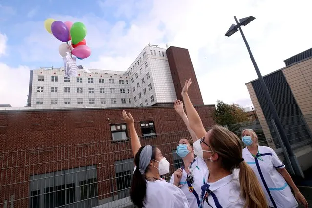 Belgian healthcare workers, nurses and doctors release balloons at the end of a flash mob to protest against the Belgian authorities' management of the coronavirus disease (COVID-19) crisis, at the CHIREC St Anne-St Remi Clinic in Brussels, Belgium, October 23, 2020. (Photo by Yves Herman/Reuters)