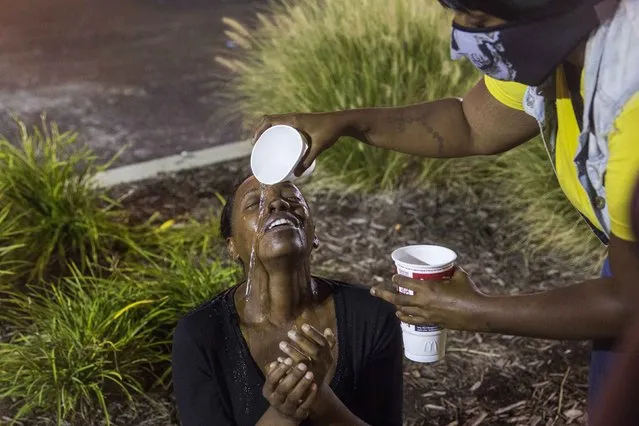 A protester is helped with the effects of tear gas after it was fired at demonstrators reacting to the shooting of Michael Brown in Ferguson, Missouri, in this August 17, 2014 file photo. (Photo by Lucas Jackson/Reuters)