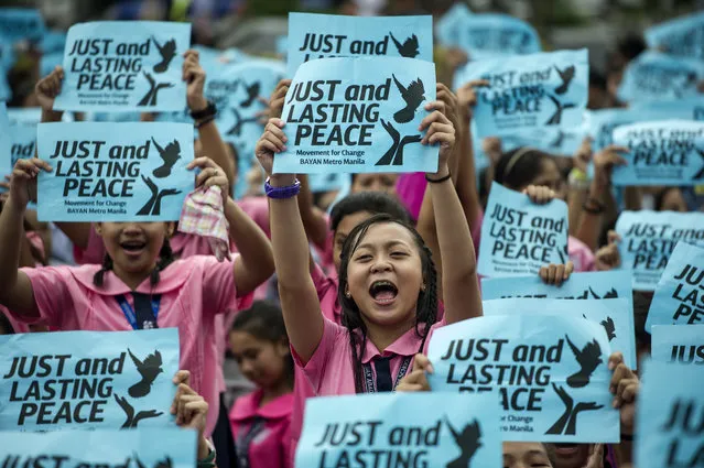 Highschool students hold banner calling for just and lasting peace in time of Philippine President Rodrigo Duterte's first 100 days in office in Manila on October 7, 2016. The group urge Duterte to end crime, drugs, and poverty through peace-building. (Photo by Noel Celis/AFP Photo)