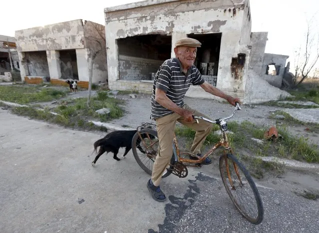 Lone inhabitant Pablo Novak, aged 85, rides his bike by a ruined house in the Epecuen Village, November 6, 2015. (Photo by Enrique Marcarian/Reuters)
