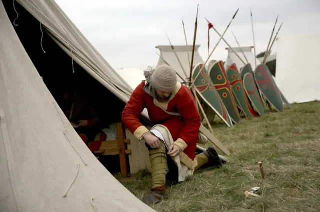 A re-enactor adjusts his costume before a re-enactment of the Battle of Hastings, commemorating the 950th anniversary of the battle, in Battle, Britain October 15, 2016. (Photo by Neil Hall/Reuters)