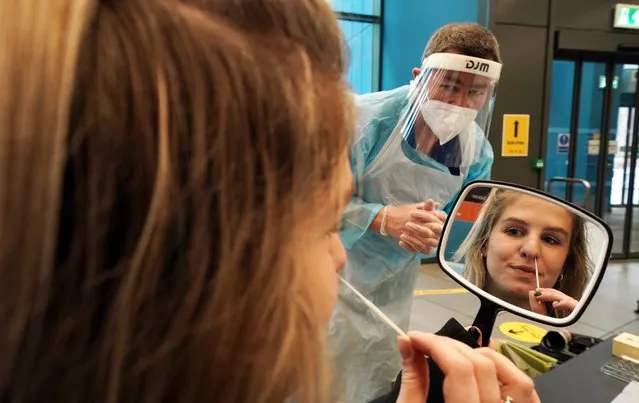 Student Amy Hariot Ingle, 22, from Newcastle University, performing a Covid-19 test on herself, watched by David Black (right) an occupational heath specialist. Amy will be part of a mass testing across the UK starting tomorrow on December 1 2020. (Photo by Owen Humphreys/PA Images via Getty Images)