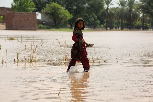 People cross a flooded area after rising floodwaters in the Sutlej River, in the Multan district, Punjab province, Pakistan, 01 September 2025. At least 33 people have died, and more than 1.4 million have been affected in Pakistan’s Punjab province after heavy monsoon rains, melting glaciers, and water releases from Indian dams caused three rivers to overflow, triggering severe flooding and 'exceptionally high' water levels, officials said. (Photo by Mansoor Abbas/EPA)