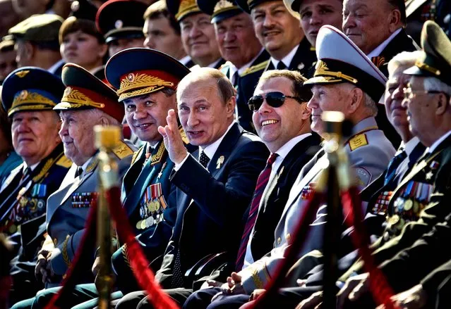 Russian Defense Minister Sergei Shoigu, center left , President Vladimir Putin, and Prime Minister Dmitry Medvedev react as they watch the Victory Day Parade in Moscow. (Photo by Alexander Zemlianichenko/Associated Press)