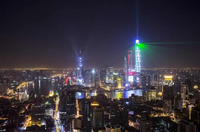 Light and laser illuminate the Lujiazui financial district of Pudong in Shanghai during a light show as part of a New Year countdown celebration on the Bund in Shanghai January 1, 2015. (Photo by Aly Song/Reuters)
