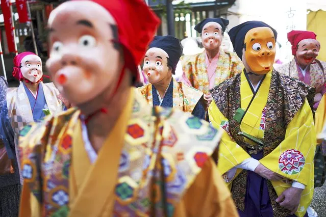 Artists wearing Japanese traditional clown masks stand for marching during the Konpira Festival at Kotohiragu shrine in Toranomon business district of Tokyo Friday, January 10, 2020. The shrine is dedicated to sailors and seafaring. (Photo by Eugene Hoshiko/AP Photo)