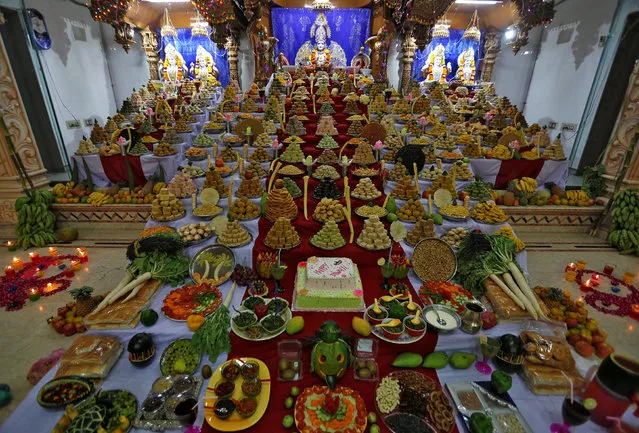 Several food items are seen in front of the idol of Lord Swaminarayan that are kept as offerings by Hindu devotees as part of a ritual to mark “Annakut” festival during Diwali, the festival of lights, celebrations at a temple in Ahmedabad, India, October 30, 2016. (Photo by Amit Dave/Reuters)