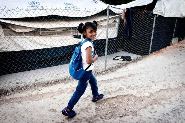 Roza, a Syrian Kurd refugee walks through a refugee camp on the island of Chios to get to a volunteer- run school on October 13, 2016 Some 270 refugee children are learning English, mathematics, arts and creative skills with “Be Aware and Share” (BAAS), a Swiss NGO which has been active on Chios since May. Operating out of a converted former restaurant in the island' s port capital, the 20- strong team runs classes for children from the age of six, as well as workshops for teenagers about cooking or going to the supermarket. The school also promotes acceptance of other national backgrounds. And hygiene, including toothbrush use. (Photo by Louisa Gouliamaki/AFP Photo)
