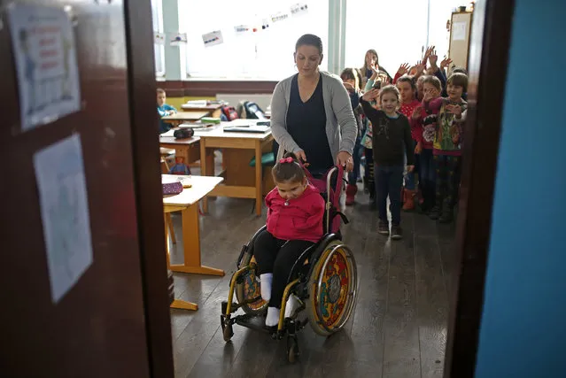 Ramela Meseljevic, a 7 year-old girl born without both of her hands and one of her legs shorter than the other, is pushed in a wheelchair by her mother Seherzada, after classes in her school in Begov Han, Bosnia and Herzegovina December 2, 2015. (Photo by Dado Ruvic/Reuters)