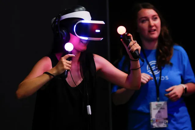 A woman plays a VR game at E3, the world's largest video game industry convention in Los Angeles, California on June 12, 2018. (Photo by Mike Blake/Reuters)