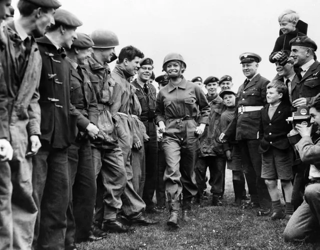 A photo taken on April 12, 1959 in London shows French actress Brigitte Bardot, flanked by Royal Air Force boys, arriving at the R.A.F. Base on the set of “Babette s'en va t'en Guerre” (“Babette Goes to War”) directed by Christian Jaque. (Photo by AFP Photo)