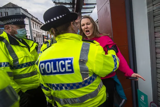 A woman without a face mask shouts and gestures towards police officers during an anti lockdown protest on November 14, 2020 in Liverpool, England. Throughout the Covid-19 pandemic, there have been recurring protests across England against lockdown restrictions and other rules meant to curb the spread of the virus. Police in Liverpool have warned protesters that they will take action against protesters, who could face possible fines. (Photo by Anthony Devlin/Getty Images)