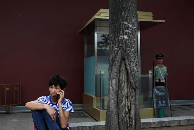 A Chinese man speaks on his mobile phone as a People's Liberation Army (PLA) soldier stand guard outside Tiananmen Square on the eve of the 29th anniversary of the 1989 June 4th Tiananmen Square protests in Beijing, China, 03 June 2018. (Photo by How Hwee Young/EPA/EFE)