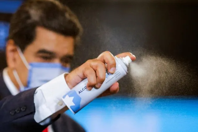 Venezuelan President Nicolas Maduro uses a disinfectant spray after a press conference following the ruling Socialist Party's victory in legislative elections that were boycotted by the opposition in Caracas, Venezuela  on December 8, 2020. (Photo by Manaure Quintero/Reuters)
