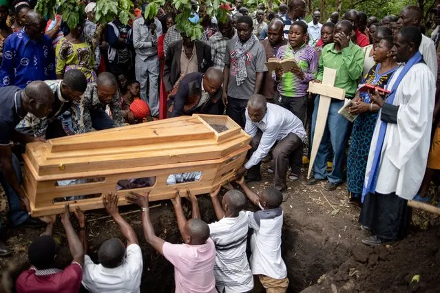 Mourners gather for funeral of Florence Masika and Zakayo Masereka during their burial rituals in Mpondwe, Uganda on June 18, 2023. Florence and Zakayo have been killed near the border with the Democratic republic of Congo by fleeing assaliants who the authorities believe to belong to the Allied Democratic Forces (ADF), a militia based in DR Congo. Grieving families prepared to bury their dead in western Uganda on Sunday while others desperately searched for loved ones still missing after militants killed dozens of students in a school attack. Officials say at least 41 people, mostly students, were massacred on Friday in the worst attack of its kind in Uganda since 2010. Victims were hacked, shot and burned in the late-night raid on Lhubiriha Secondary School in Mpondwe, which lies less than two kilometres (1.2 miles) from the border with the Democratic Republic of Congo. (Photo by Stuart Tibaweswa/AFP Photo)