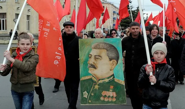 People carry red flags and a portrait of Soviet dictator Joseph Stalin during a march on December 21, 2015, in his native town of Gori, west of Tbilisi, to mark the 136th anniversary of his birth. (Photo by Vano ShlamovAFP Photo)